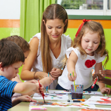 Kindergartenerzieherin spielt mit Kindern