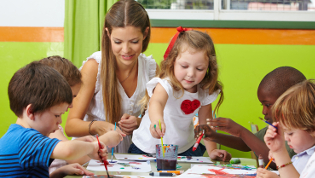 Kindergartenerzieherin spielt mit Kindern