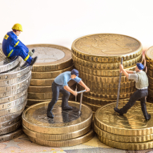 Mindestlohn, Arbeitnehmer arbeiten auf Euro-Münzen