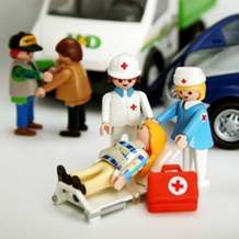 Verkehrsunfall mit verletzter Frau und Sanitätern im Vordergrund