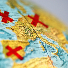 Globus mit Europa im Vordergrund, gekreuzte rote Klebestreifen auf einigen Ländern