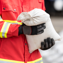 Ehrenamtliche Helfer von Hilfsorganisationen, Sandsäcke stapeln, Katastrophenhilfe