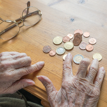 Altersarmut, knappe Rente, Seniorin zählt Geldmünzen
