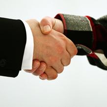 Handschlag, eine Hand mit weißem Hemd und Anzugjacke, eine Hand mit Flanellhemd