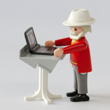 Rentner mit Laptop an Stehtisch
