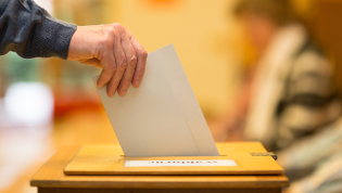 Stimmzettel in Wahlurne werden, Betriebsratswahl